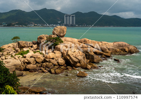 Nha Trang Vietnamese resort coastline is revealed in vibrant spectacle. picturesque rocky coast meet azure sea under radiant sun, panorama of beaches and crystal-clear waters 110997574