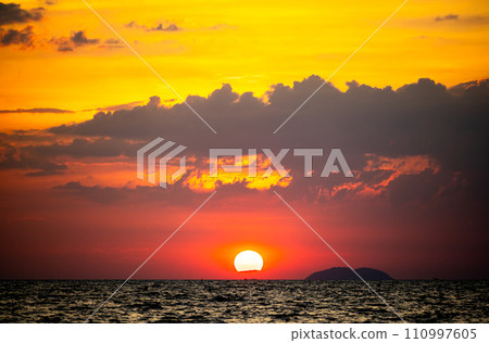 fiery sunset over ocean, with vibrant shades of orange and red painting sky. sun sets dramatically, casting warm glow on dark waters below, creating breathtaking reflection of nature's stunning canvas fiery sunset over ocean, with vibrant shades of orange and red painting sky. sun sets dramatically, casting warm glow on dark waters below, creating breathtaking reflection of nature's stunning canvas 110997605