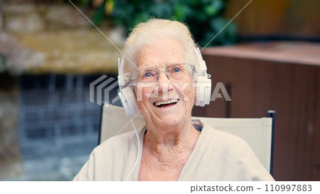 Senior podcaster and influencer waving at camera 110997883