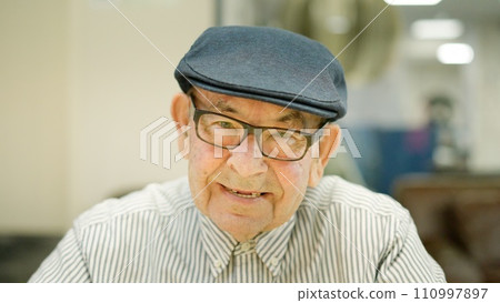 Senior man with beret smiling at camera Senior man with beret smiling at camera 110997897