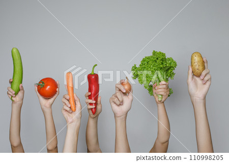 Hands with fresh vegetables isolated on gray background. Organic food and healthy eating concept Hands with fresh vegetables isolated on gray background. Organic food and healthy eating concept 110998205