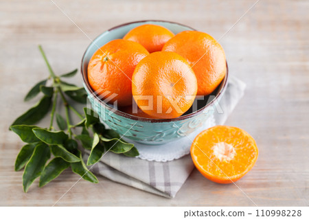 Season tangerine fruit on light brown wooden board background 110998228