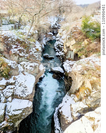 River flowing in the snow 110998481