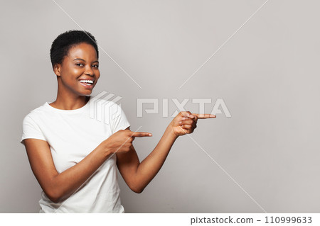Pretty woman pointing finger at light gray studio wall banner background Pretty woman pointing finger at light gray studio wall banner background 110999633