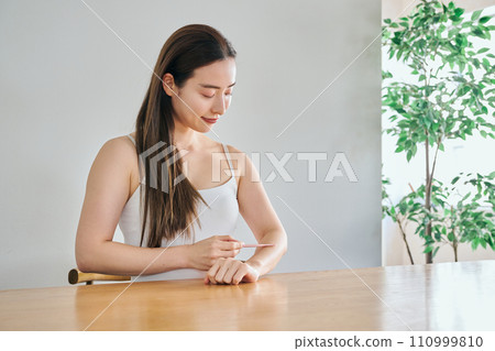 一名30多歲的女性用女士刮鬍刀剃掉手臂上的毛髮 一名30多歲的女性用女士刮鬍刀剃掉手臂上的毛髮 110999810