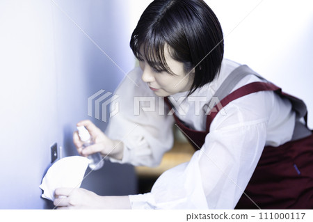 A woman in an apron disinfecting A woman in an apron disinfecting 111000117