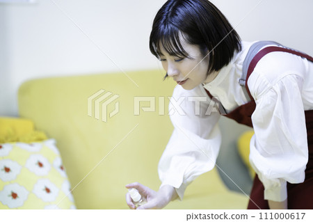 圍裙的女人給沙發消毒 圍裙的女人給沙發消毒 111000617