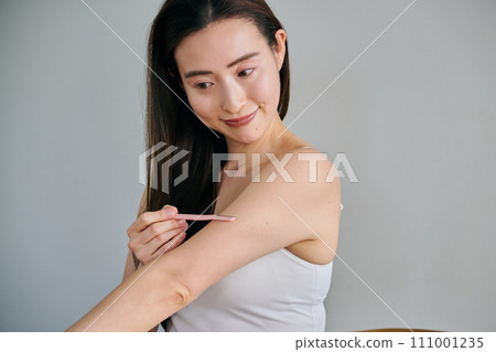 A woman in her 30s shaving her arm hair with a ladies razor A woman in her 30s shaving her arm hair with a ladies razor 111001235