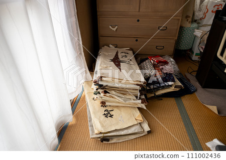 A Japanese-style room where unnecessary kimonos are piled up after being removed from a Japanese dance room to organize them. 111002436