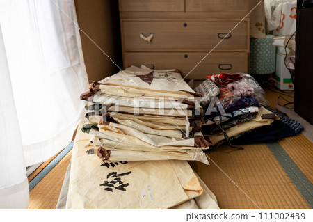 A Japanese-style room where unnecessary kimonos are piled up after being removed from a Japanese dance room to organize them. 111002439