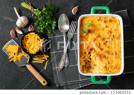 cheesy smoked sausage grits bake in ceramic dish 111003551