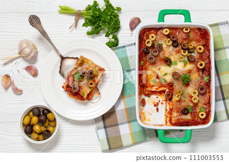 lasagna with olive rings in green baking dish lasagna with olive rings in green baking dish 111003553