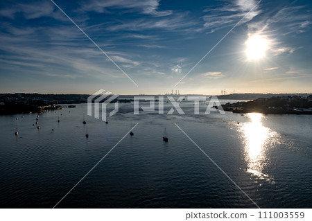 View From Cleddau Bridge To River Estuary With Pembrokshire Docks, Wind Turbines And Factories In Wales, United Kingdom View From Cleddau Bridge To River Estuary With Pembrokshire Docks, Wind Turbines And Factories In Wales, United Kingdom 111003559