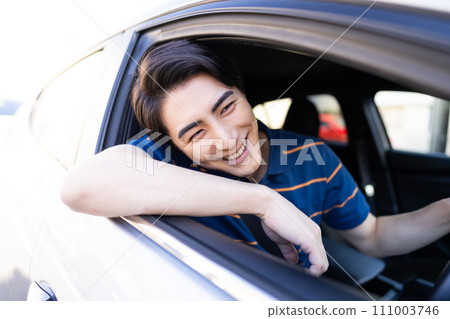 A young man wearing a polo shirt driving in the summer 111003746
