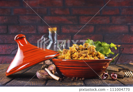 Tagine with traditional uzbek pilaf on a table Tagine with traditional uzbek pilaf on a table 111004770