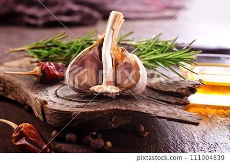 garlic rosemary and oil on wooden board garlic rosemary and oil on wooden board 111004839