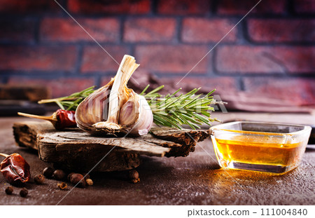 garlic rosemary and oil on wooden board 111004840