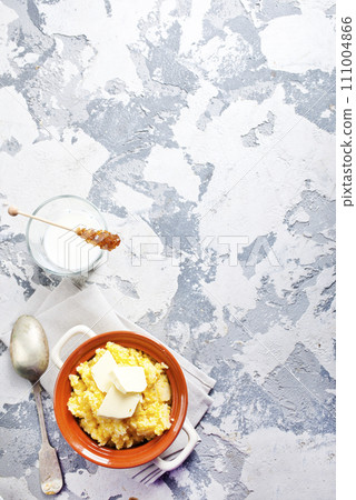 Polento corn porridge on a gray background in a brown plate. 111004866