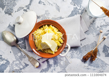 Polento corn porridge on a gray background in a brown plate. 111004874