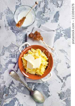 Polento corn porridge on a gray background in a brown plate. 111004876