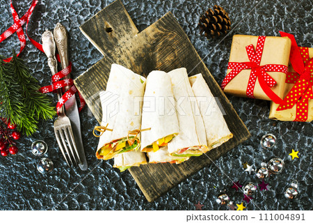 Salmon and cream cheese wraps. Rolls with smoked salmon, basil and rocket salad. Burrito on serving board 111004891