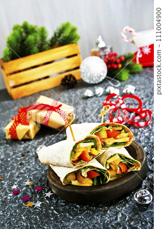 Salmon and cream cheese wraps. Rolls with smoked salmon, basil and rocket salad. Burrito on serving board 111004900