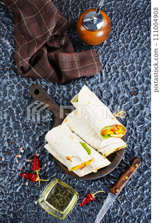 Salmon and cream cheese wraps. Rolls with smoked salmon, basil and rocket salad. Burrito on serving board 111004908