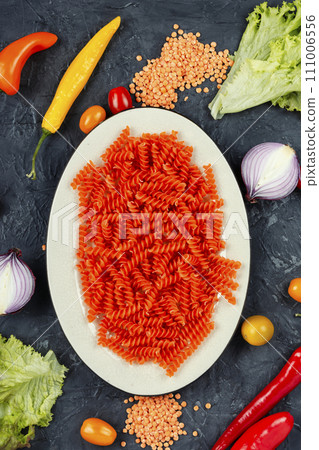 Raw orange spiral noodles. Raw orange spiral noodles. 111006556