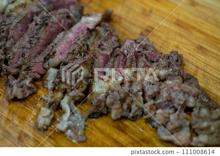 Medium rare sliced meat on wooden cutting board 111008614