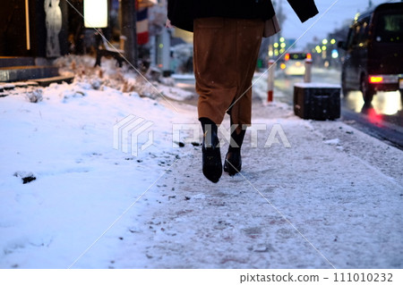 一個女人穿著高跟鞋走在雪路上的腳 111010232