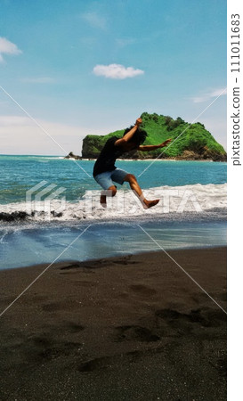 man doing yoga on the beach 111011683