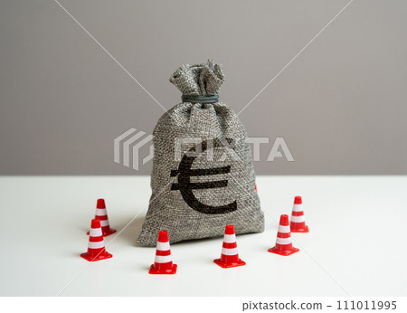Euro money bag blocked by road cones. Suspicious funds with unknown sources. National money reserve. Freezing of accounts and sanctions on capital. 111011995