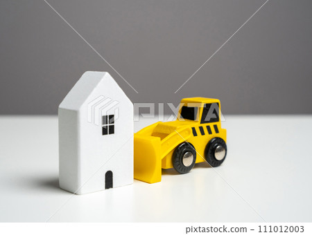 Bulldozer demolishing the house - concept. Illegal buildings construction. Lawsuit. Illegal construction or demolition of a building. Plan for the renewal and restoration of residential areas. Bulldozer demolishing the house - concept. Illegal buildings construction. Lawsuit. Illegal construction or demolition of a building. Plan for the renewal and restoration of residential areas. 111012003