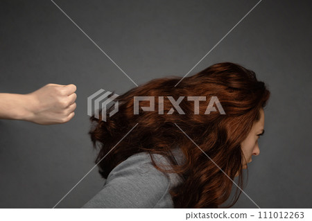 A woman's fist hits a woman in the head. Problems of mutual understanding, conflict and psychology. Domestic violence A woman's fist hits a woman in the head. Problems of mutual understanding, conflict and psychology. Domestic violence 111012263