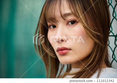靠在鐵絲網上的年輕女子 111012342