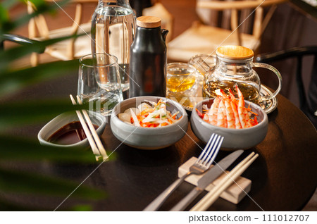 Shrimp sashimi on a plate on a table in a sushi bar. 111012707