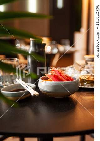 Tuna sashimi on a plate on a table in a sushi bar. 111012708