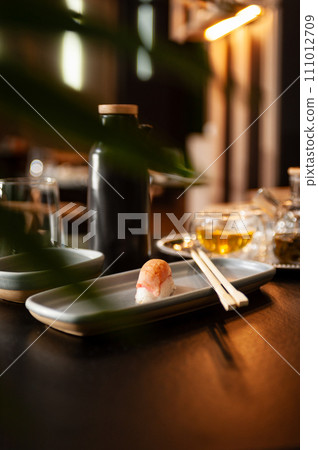 Nigiri tuna tataki on a plate on a table in a sushi bar. 111012709