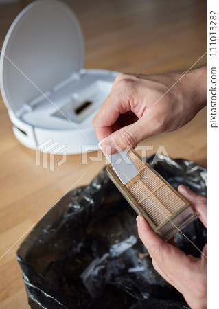 Cleaning the filter of the vacuum robot cleaner from dirt, close-up. Cleaning the filter of the vacuum robot cleaner from dirt, close-up. 111013282