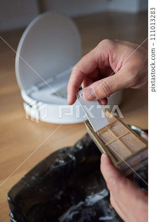 Cleaning the filter of the vacuum robot cleaner from dirt, close-up. Cleaning the filter of the vacuum robot cleaner from dirt, close-up. 111013283