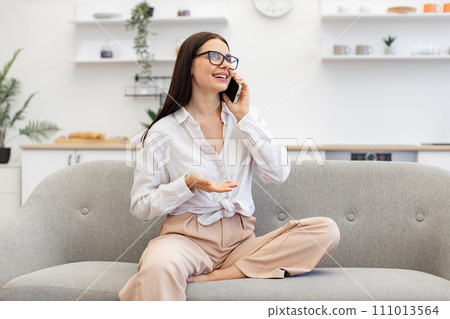 Female gesturing while having conversation on smartphone, staying at home. Female gesturing while having conversation on smartphone, staying at home. 111013564