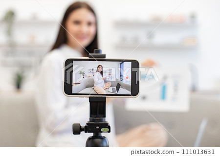 Young caucasian brunette financier woman filming herself on cell phone. 111013631