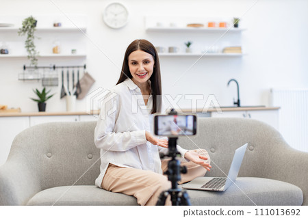 Cheerful content maker recording video to followers on modern smartphone. Cheerful content maker recording video to followers on modern smartphone. 111013692