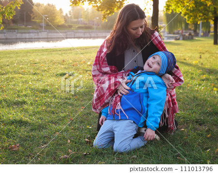 Mom and son in the park in warm clothes in spring Mom and son in the park in warm clothes in spring 111013796