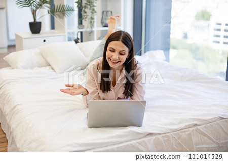 Woman in casual attire enjoying online conversation with friends. Woman in casual attire enjoying online conversation with friends. 111014529