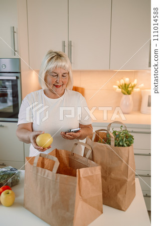 Portrait of woman unpacking paper box with food while enjoying delivery from farmers market, copy space 111014588