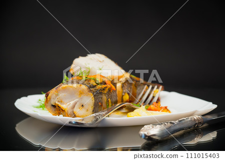 fish baked with spices and vegetables in the oven. fish baked with spices and vegetables in the oven. 111015403