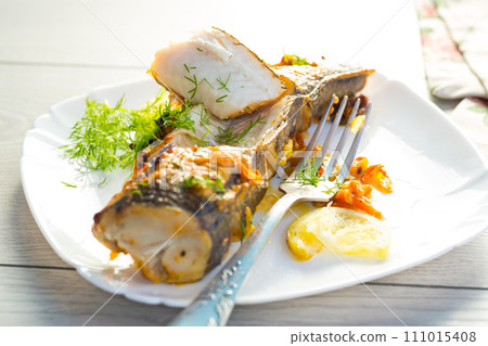 fish baked with spices and vegetables in the oven. fish baked with spices and vegetables in the oven. 111015408
