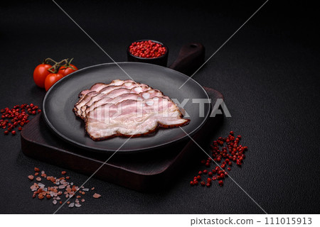 Delicious fresh pancetta or bacon with salt and spices cut into thin slices Delicious fresh pancetta or bacon with salt and spices cut into thin slices 111015913