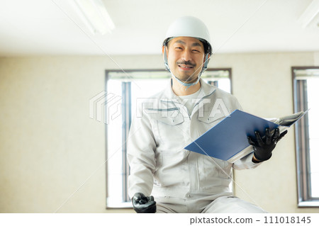A man in work clothes inspecting the ceiling A man in work clothes inspecting the ceiling 111018145
